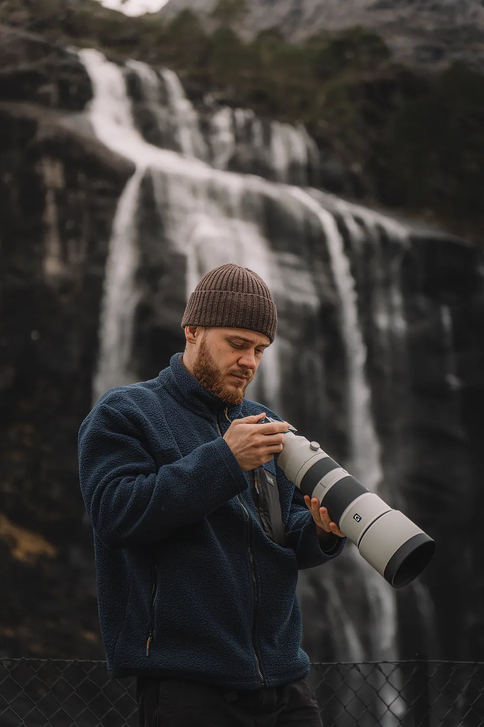 Adam with his camera by a waterfall in Norway